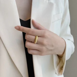 18K gold ribbed ring worn on hand close-up showing fit and texture detail with white blazer