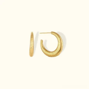 18K gold ribbed C-hoop earrings top-down view showing grooved texture and polished finish on plain background