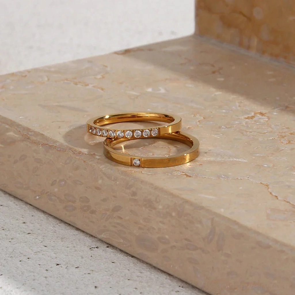 Two-piece 18K gold ring set flat lay, mono and poly styles together on marble countertop display
