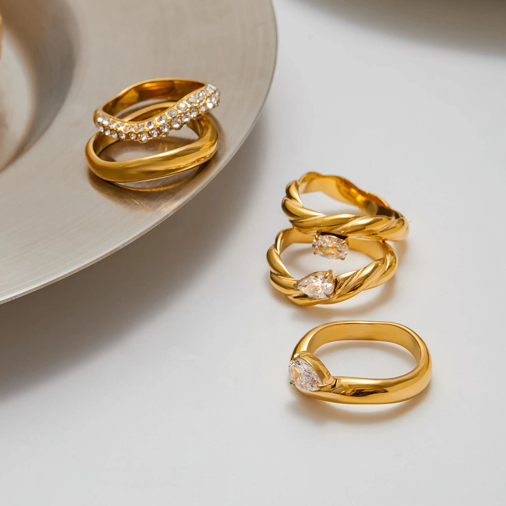Flat lay top-down view of assorted 18K gold ring collection with multiple twisted band styles