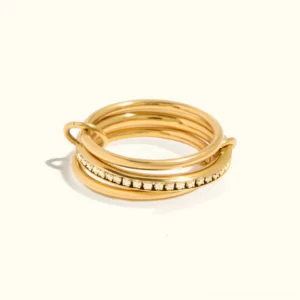 18k gold diamond simulant ring stack flat lay top view three-band set with pavé crystal details on white background