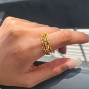 18k gold stackable ring set worn on female hand side close-up twisted bands crystal pavé accents indoor