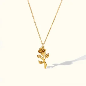 18K gold rose pendant necklace flat lay front view with intricate carved rose and delicate gold chain