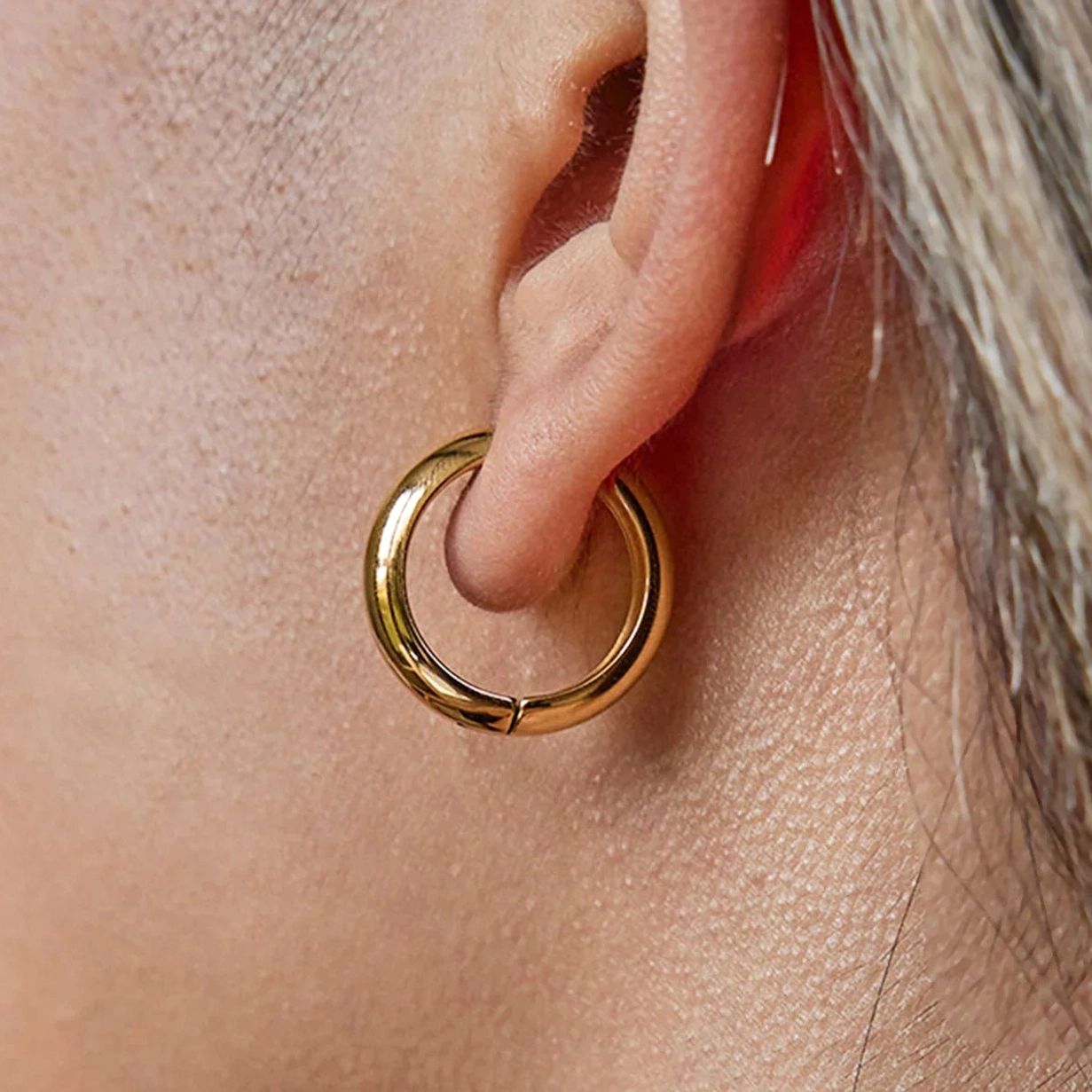 Classic 18mm round gold hoop earrings medium size worn on ear displaying traditional hoop style