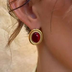 18K gold gemstone earrings on ear close-up side view showing vintage gold frame and ruby cabochon stone