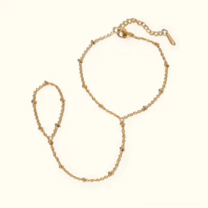 18K gold satellite chain hand bracelet flat lay top-down view on plain white background showing delicate beaded chain design