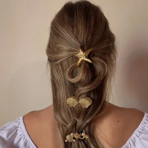 ocean-inspired gold seashell hair clip worn on long braided hair back view styling demonstration