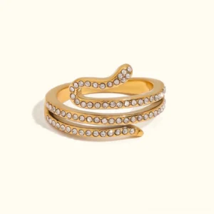 Serpentina 18K gold layered diamond ring with spiral serpent design and crystal pavé detailing, flat lay view on plain background