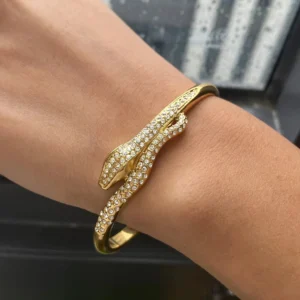 18K gold serpentine diamond cuff bracelet worn on wrist close-up showing diamond simulant embellishments