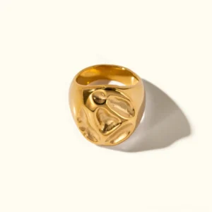 18K gold textured signet ring with organic carved pebble pattern, top-down flat lay view on plain background