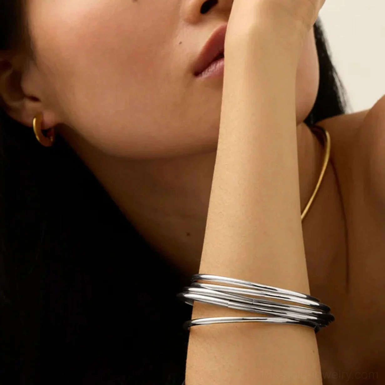 Two-tone bangle set - separated gold and silver stacked bracelets on woman's wrist