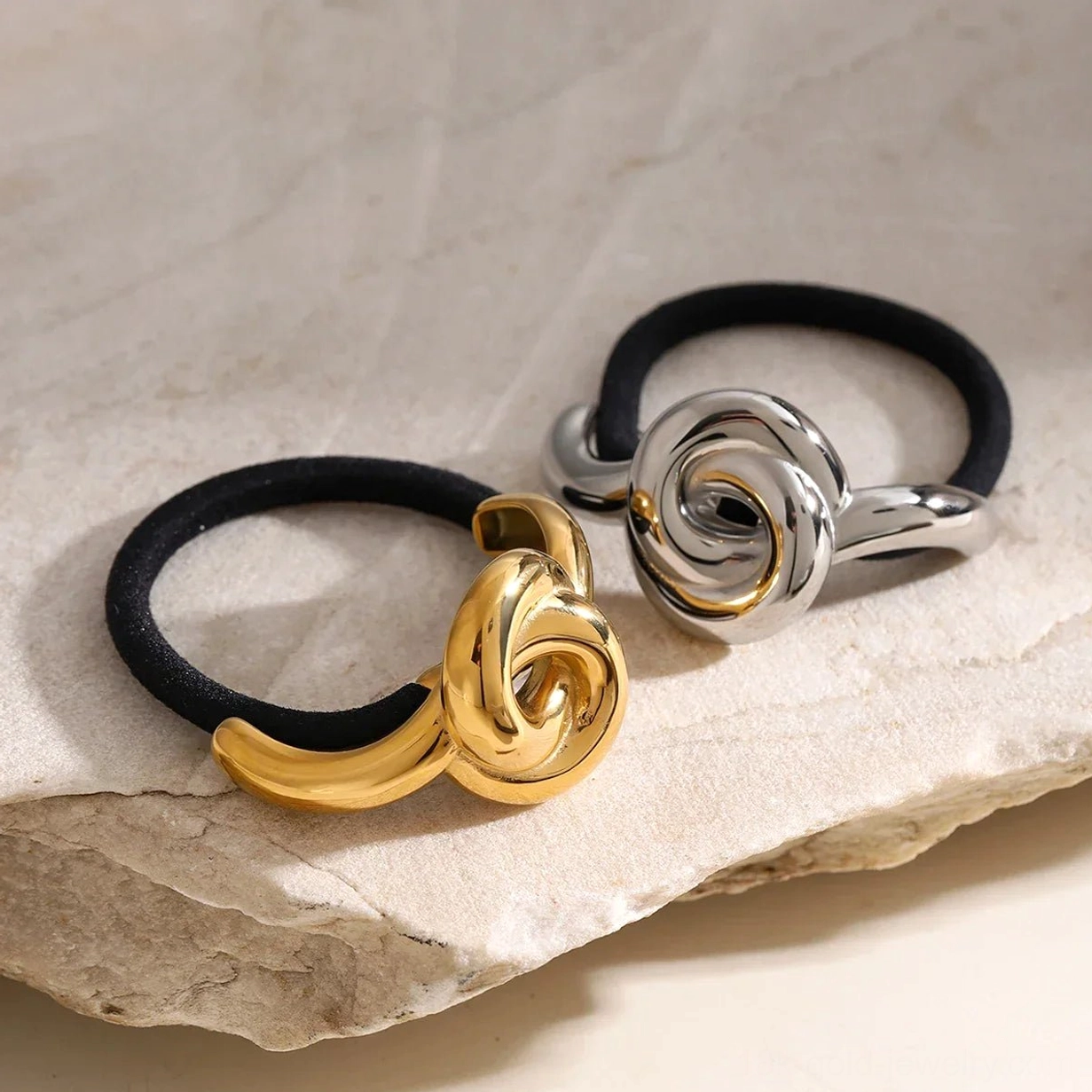 Pair of rose knot hair cuffs gold and silver tones close-up side angle