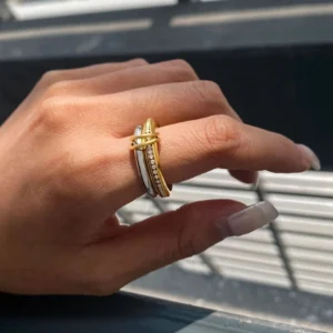 Model wearing two-tone stackable rings on hand, side angle close-up showing gold pavé and silver bands worn on fingers outdoors