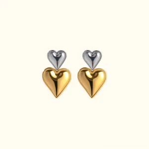 Two-tone 18K gold and silver stacked heart drop earrings, flat lay front view on plain white studio backdrop, showing polished glossy finish