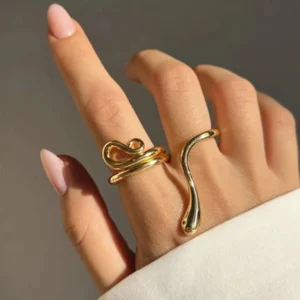 Two 18k gold snake rings worn on model hand close-up jewelry detail manicure