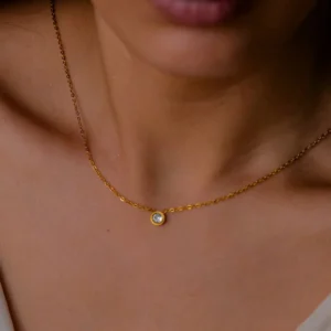 Minimalist 18K gold choker necklace worn on female neck, showcasing dainty single pendant design and elegant drape against bare skin