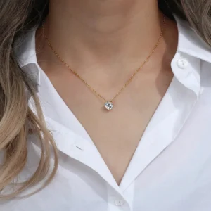 Minimalist gold necklace worn on model with white button-down shirt, delicate solitaire pendant at neck, dainty chain close-up