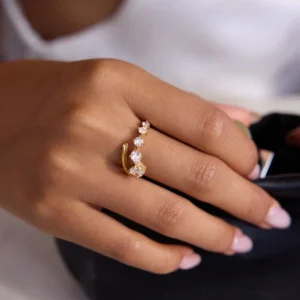 18K gold spiral ring worn on hand with prong-set CZ stones side profile lifestyle shot