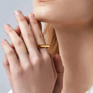 Minimalist square gold ring on model hand close-up eye level view contemporary jewelry design