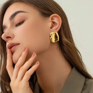 18K gold chunky square stud earrings worn on model left ear profile close-up