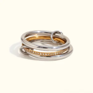 18K gold stackable diamond ring set featuring dual-tone bands with pavé crystal accents, front view on plain background showing complete three-ring collection