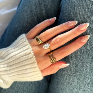 Stackable 18K gold rings worn on hand - close-up showing mixed styles including pavé solitaire, plain band and twisted design