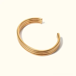 18K gold stacked cuff bracelet with multiple layered open bands in rich gold tone, front flat lay view