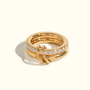 18K gold stacked diamond knot ring set flat lay with interlocking pavé CZ bands plain background