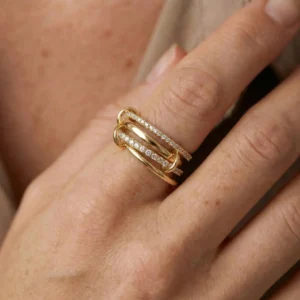 Stacked diamond ring worn on hand close-up side view showing pavé stone bands and gold finish