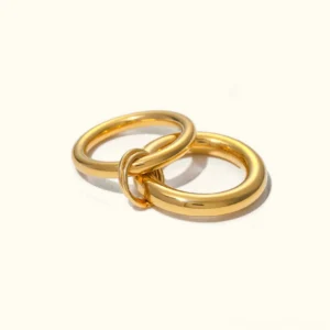 18K gold stacked interlocking ring polished chunky layered band flat lay studio view
