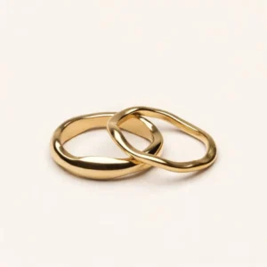 18K gold minimalist stacker ring intertwined design flat lay top view white background