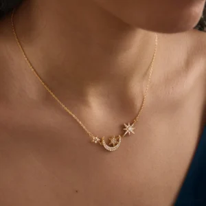 18K gold star moon pendant necklace single strand front close-up shot showing pavé diamond simulant detailing on model chest