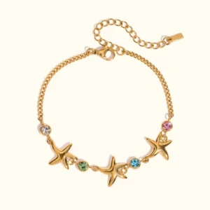 18K gold starfish charm bracelet with colorful gemstone accents displayed on plain background - flat lay product photography