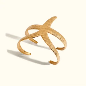 18K gold starfish open cuff bracelet flat lay overhead view polished textured starfish arms white background