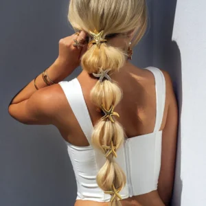 Back view of blonde woman wearing multiple shimmering 18k gold starfish hair cuffs with spiral charm detail on bubble ponytail braid