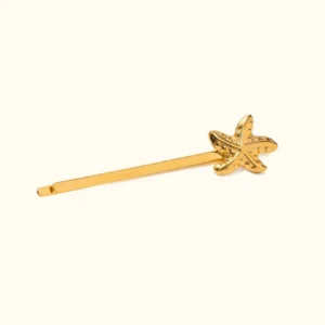 18K gold starfish hair pin with embossed starfish charm, polished gold finish, side flat lay view on plain background