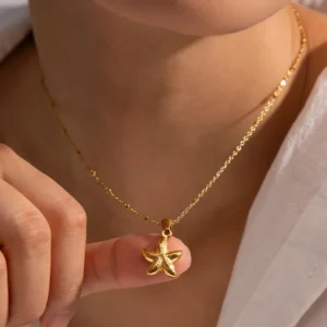 Delicate 18K gold starfish necklace worn on model showing pendant charm and fine cable chain
