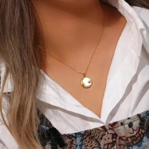 Sun and moon gold necklace worn on neck, upper body styling with white collared shirt, delicate dainty pendant at collarbone, real-life wear demonstration