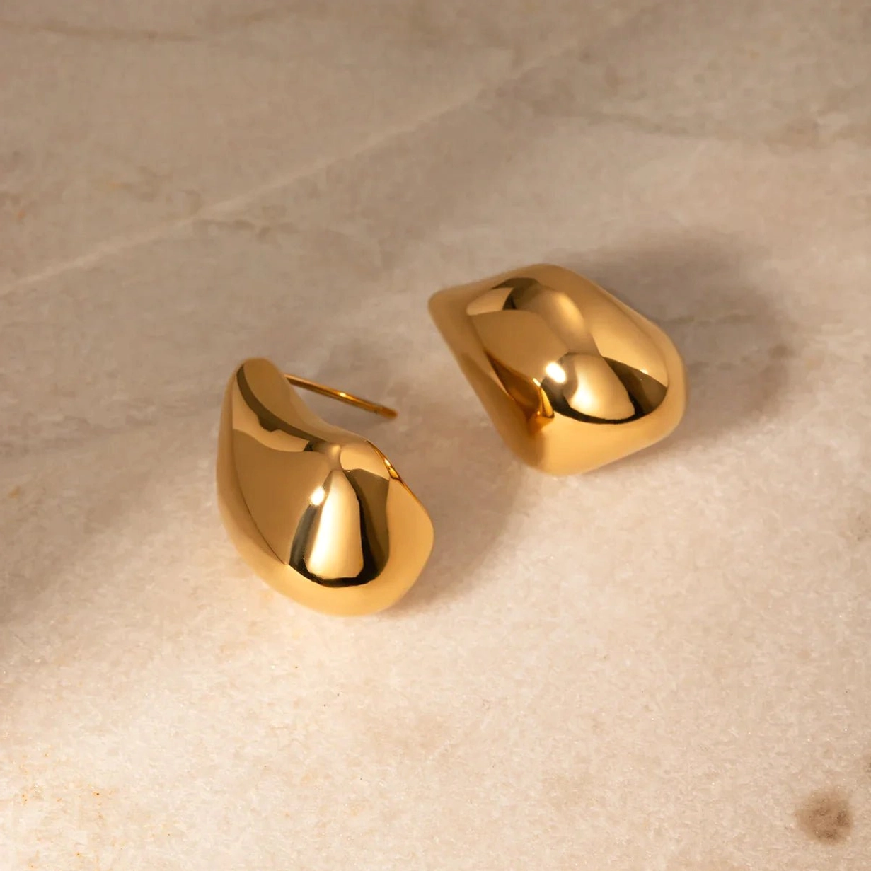 18K gold teardrop stud earrings marble background compact minimalist design
