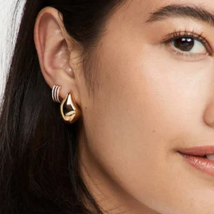18K gold teardrop drop earrings worn on model ear closeup professional style