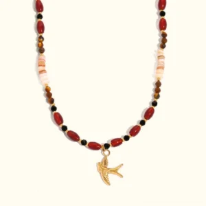 18K gold tiger eye beads necklace with swallow charm, flat lay front view on neutral background showing mixed earthy tone beads and delicate bird pendant