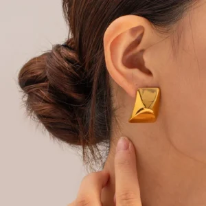 gold geometric stud earrings worn on ear close-up side view model