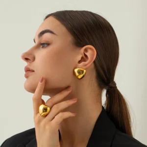 Woman wearing gold geometric triangle studs with matching ring profile portrait professional styling