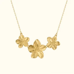18K gold triple flower necklace flat lay featuring three delicate 5-petal botanical pendants on thin gold cable chain, front view product photography