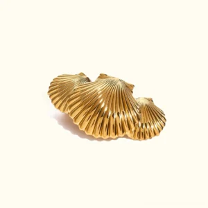 18K gold triple scallop shell hair clip flat lay top-down view showing detailed ribbed texture and polished gold finish