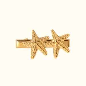 18K gold tropical starfish hair clip front view flat lay, polished gold finish with embossed starfish details and alligator clip base, waterproof beach accessory