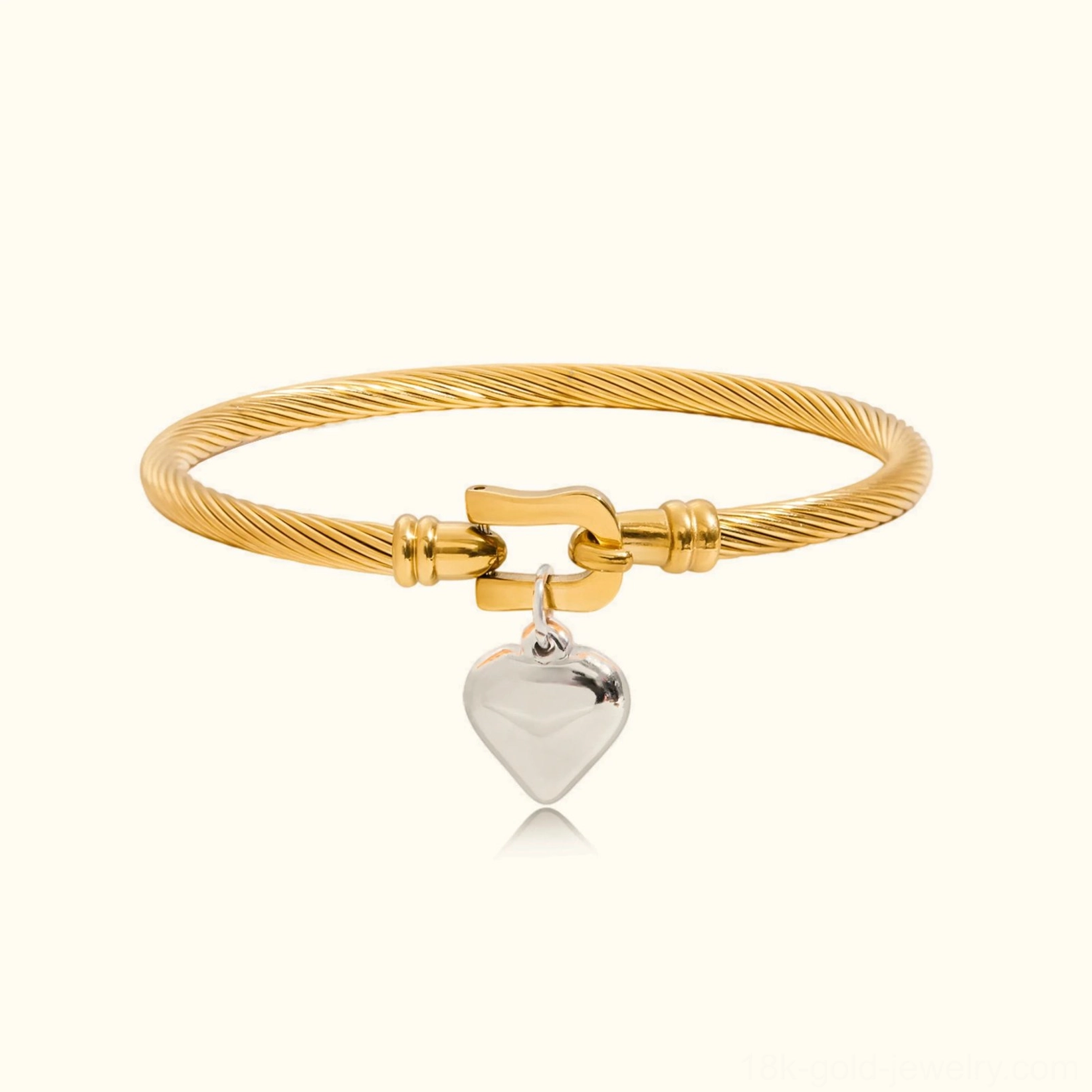 18K gold twisted cable bracelet with silver heart charm, flat lay front view on plain background showing coiled rope texture and two-tone finish