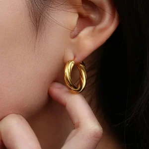 18K gold twisted hoop earrings worn on female model ear, close-up side view showing polished finish