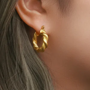 18K gold twisted hoop earrings worn on ear close-up side profile shiny finish