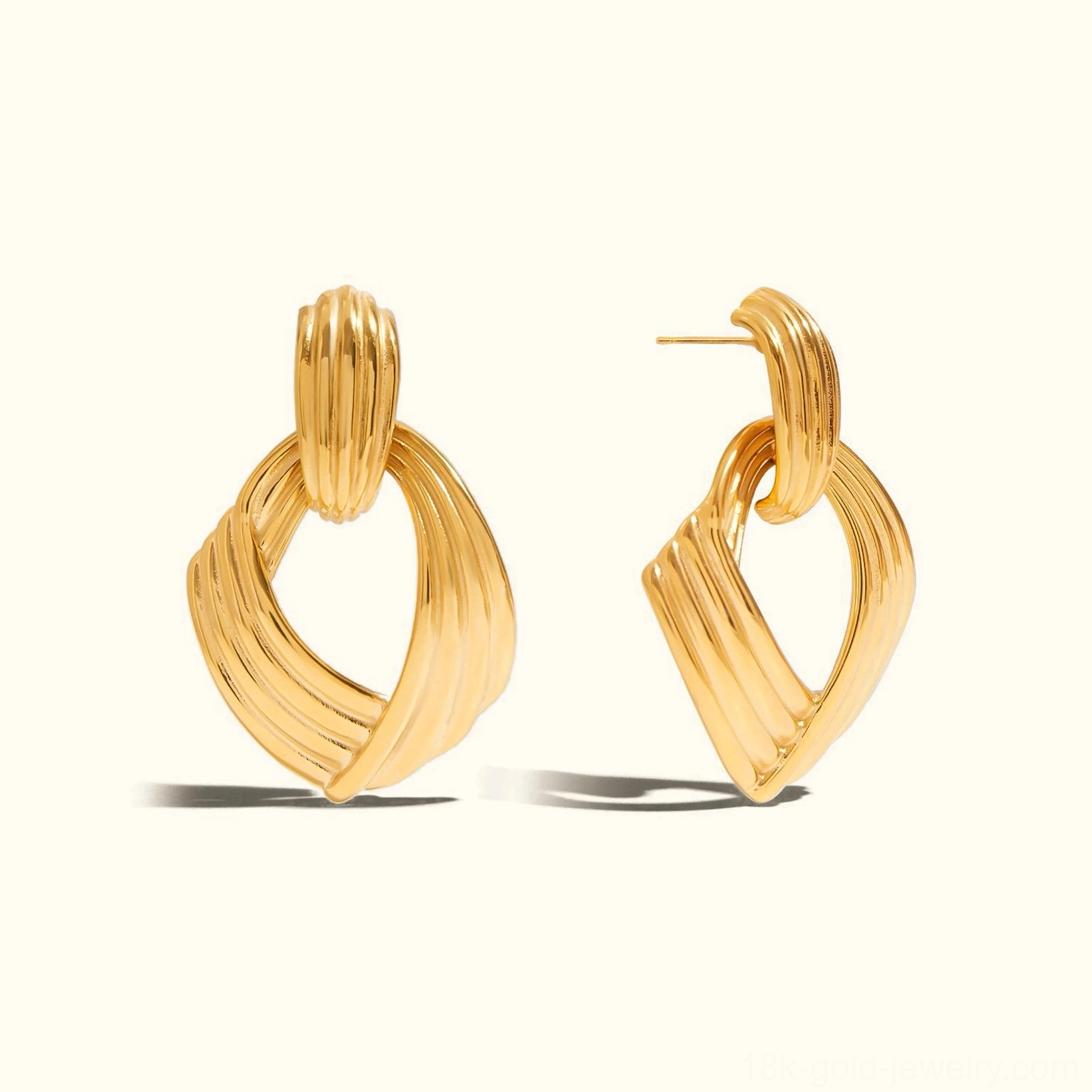 18K gold twisted knot drop earrings front flat lay product display ribbed textured surface
